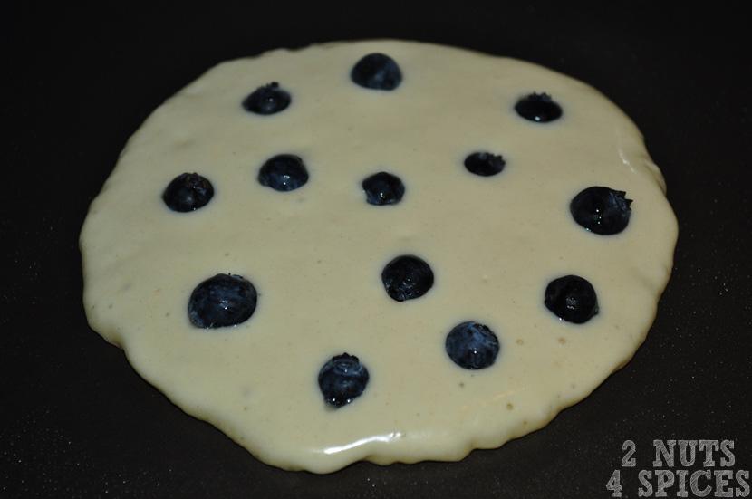 Assim que você colocar a massa na frigideira, coloque os blueberries (mirtilos) sobre a massa, distribuindo as frutinhas de forma uniforme e harmônica, dando