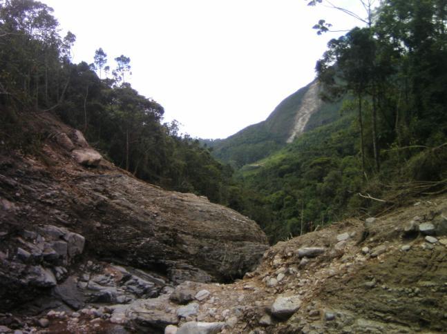 Esse fluxo também sofreu o acréscimo da acentuada concentração águas pluviais vindos dos taludes laterais e de áreas a montante, o que aumentou sua velocidade e viscosidade, possibilitando seu avanço