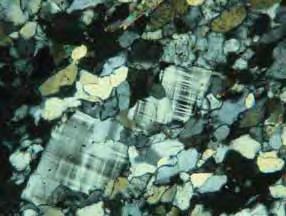 Os cristais de quartzo ocorrem comumente em faixas de até 1 mm de espessura intercaladas a bandas plagioclásio; ocorrem também em menor quantidade em meio aos cristais de feldspato.