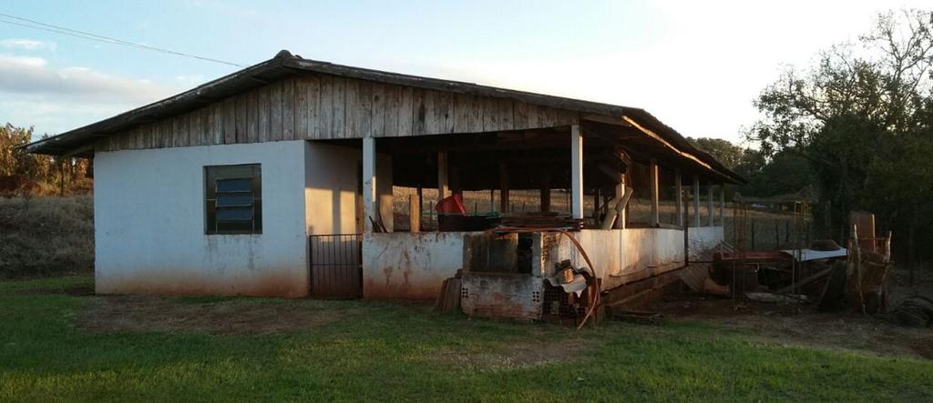 2) (uma) Edificação de Chiqueiro de Porcos / Mangueirão, de aproximadamente 200,m2, em alvenaria de 1 metro de altura e, cobertura de Eternit; com pequena dispensa de materiais em alvenaria; janela