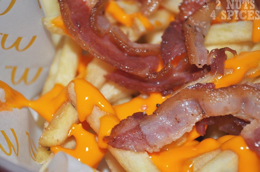 A McFritas Cheddar Bacon é uma McFritas Média que vem em uma embalagem de papel, com cobertura de cheddar e com bacon cortadinho. A quantidade de bacon e de cheddar é generosa.