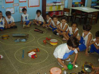 2º Momento: O professor deverá desenhar três grandes círculos no meio da roda com giz, para as crianças colocarem em cada um deles os instrumentos musicais: percussão, sopro e corda.