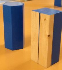 Dois prismas hexagonais de madeira pintadas de azul, um dividido e o outro não.
