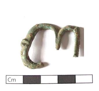 FIVELA Exemplar incompleto em cobre. O artefacto apresenta uma moldura dupla ligeiramente ovalada ou em oito.