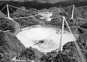 Figura 2.2 - Radiotelescópio de Arecibo, localizado em Porto Rico. Fonte: (NAIC, 2004) terferômetros são apresentadas na Seção 2.2. As Seções 2.3 e 2.