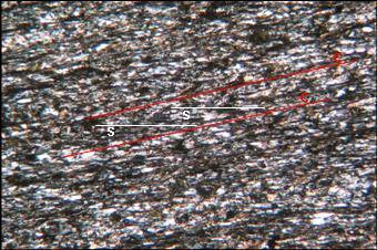Foto 8 Foliação S-C em metapelito carbonoso. Fotomicrografia da amostra MC-28. Objetiva 5x, nicóis cruzados.