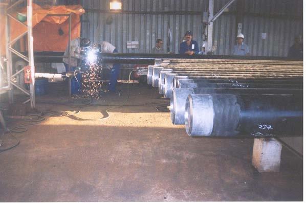 O préaquecimento e a preparação das extremidades dos tubos para a soldagem ocorre no final dos racks de alimentação, adjacentes à linha de produção.