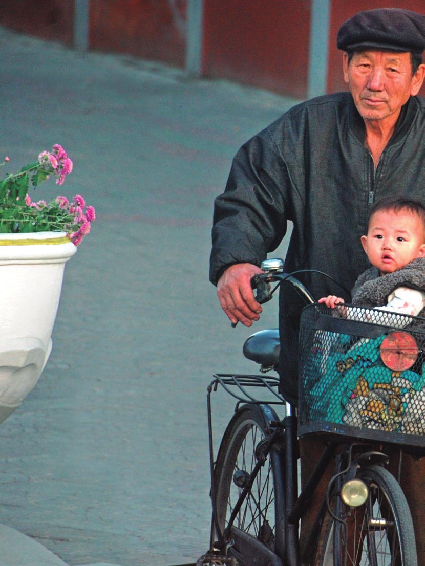 Avô e neto passeiam na Coreia do Norte, país onde é