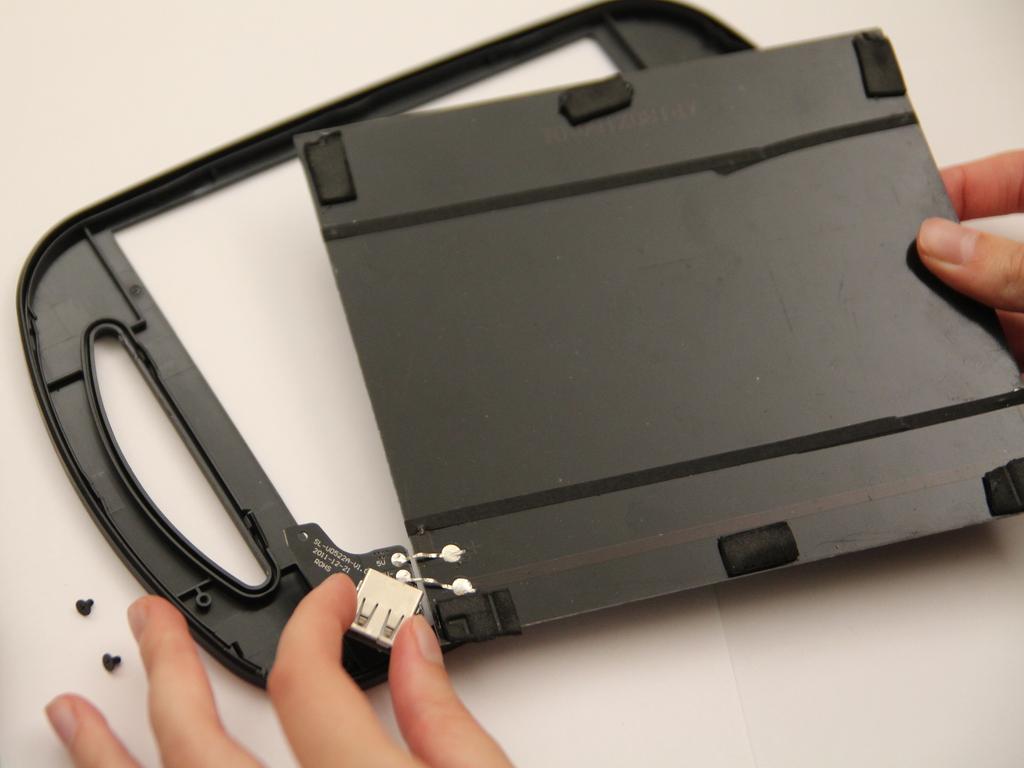 Passo 13 Sustentando tanto a porta USB e o painel solar, remova tanto a placa de circuito e painel solar da