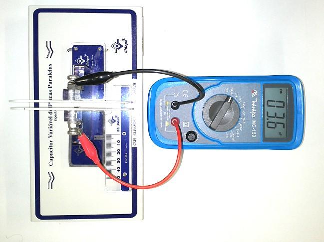 do capacímetro; Em seguida mova a placa móvel até está encostar na placa fixa; Neste momento verifique se o traço na placa móvel encontra com o zero na escala milimetrada, fixada à base do capacitor;