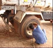 26 Preparação do caminhão para os ensaios: (a) Carregamento do solo; (b) Verificação do peso na roda traseira; (c) Aferição dos pneus Os equipamentos (Viga Benkelman, Prova de Carga e DCP) foram