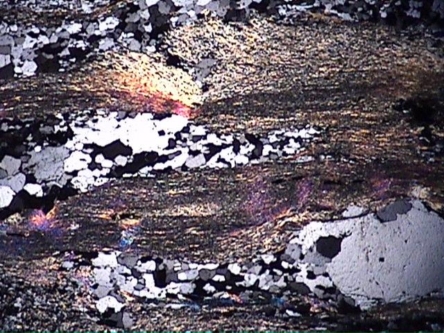 a b 1,0mm 1,0mm c d 1,0mm 1,0mm Figura 5.2.5. Fotomicrografias de quartzo-moscovita xisto milonítico da Formação Barão do Guaicuí.