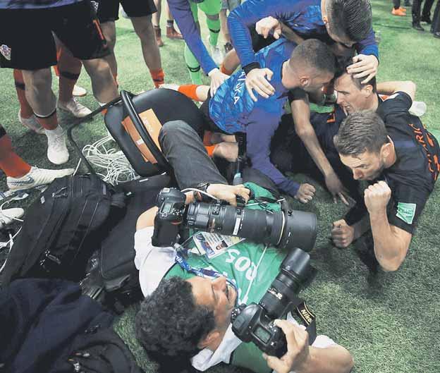 Mexický reportér Yuri Cortez z agentúry AFP sa ocitol v stredu pod jasajúcou lavínou chorvátskych futbalistov, napriek tomu pokračoval vo fotení a vďaka tomu ulovil