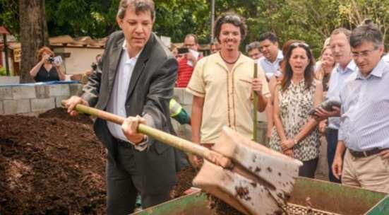 center) looks at the (former) mayor of São Paulo learning how to screen compost.