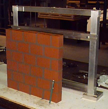 (a) (b) (c) FIGURA 3-9 Modelo de pequenas paredes: (a) Gabarito de alumínio e parede recém construída; (b) Ensaio de compressão
