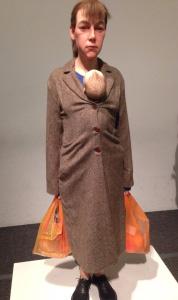 Em uma escultura de Ron Mueck, de 2013, chamada de Woman with shopping, percebe-se através da expressão artística uma manifestação do olhar congelado e cansado de uma mãe, que apenas carrega um bebê,