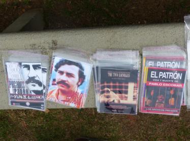281, 282 e 283: Imãs de geladeira e adesivos vendidos durante o Tour Pablo Escobar Gaviria, com imagens do El Patrón; cópias de fotos de Pablo Escobar e de um cartaz de busca do