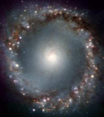 Imagens infravermelhas combinadas da Galáxia Ativa NGC 1097 (ESO's Very Large Telescope, Chile) Nota-se uma rede complexa de estrutura filamentar espiralando em direção ao centro da