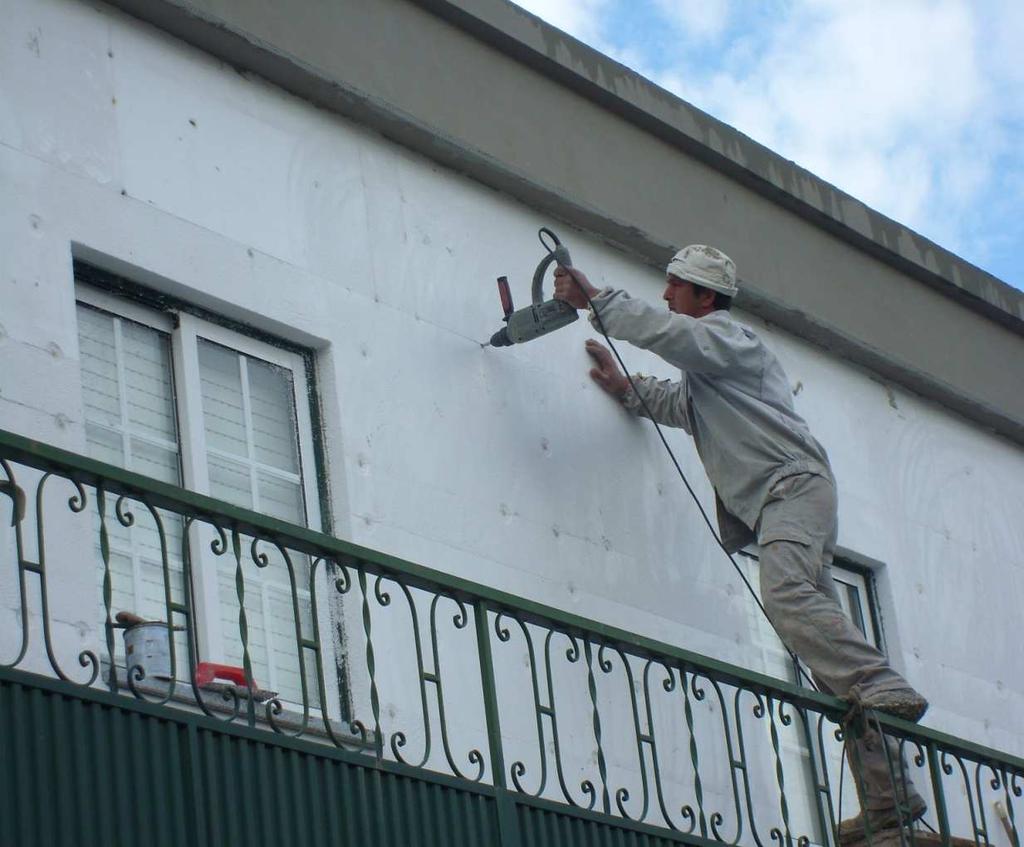 Aplicação da primeira camada de base sobre as placas de EPS, com talocha denteada, após o endurecimento da argamassa de colagem, garantindo a