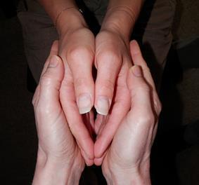 Peça à receptora para colocar suas mãos na posição de Yoni. Gentilmente segure suas mãos ao redor das mãos dela. (Veja a fotografia).