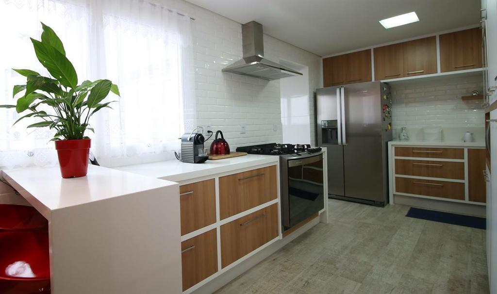 A cozinha foi planejada para maximizar o espaço, tornando-o agradável, funcional e integrando com balcão para refeições rápidas.
