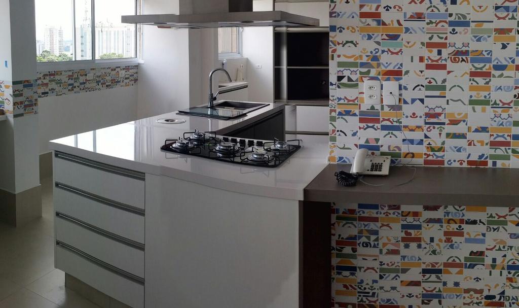 Essa cozinha harmonizada combina o colorido da parede, com o acabamento em branco e bancada em