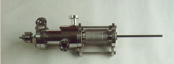 Tal tubo é necessário para que seja possível o alinhamento da lâmpada de hélio em relação à amostra, após a conexão ao sistema de UHV.