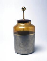 Dispositivo composto por uma garrafa de vidro com água no seu interior, tampada com uma rolha perfurada por uma haste metálica que ficava em