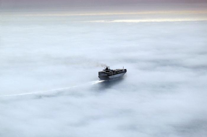 3. PICOS ROCHOSOS: Alguns cumes de montanhas próximas rompem o véu de névoa como rochas recortadas emergindo do mar.