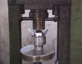 A deformação foi aplicada na chapa soldada através da esfera por meio de uma prensa hidráulica manual. A Figura 13.