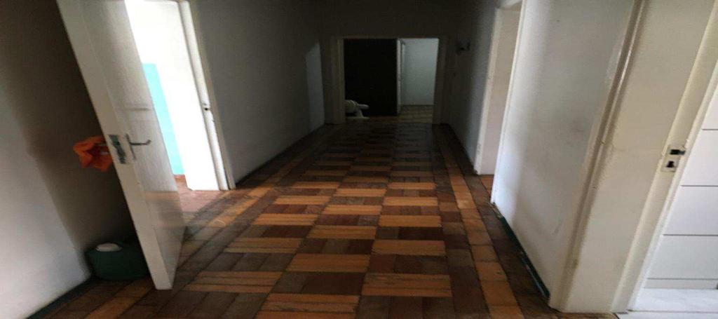 Foto 04 - Corredor que dá acesso aos quartos e banheiro, com forro e paredes rebocados com pintura e piso de tacos de